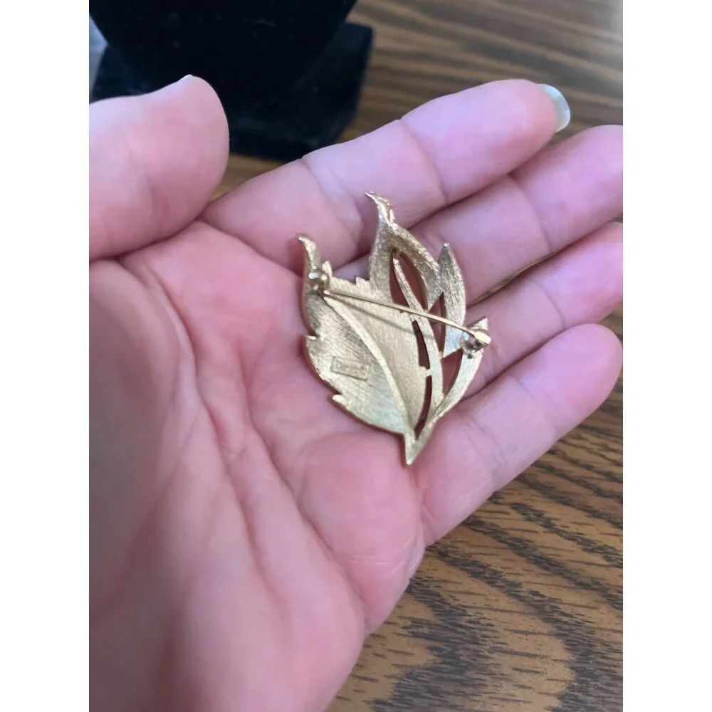Crown Trifari gold tone and white enamel leaf design brooch